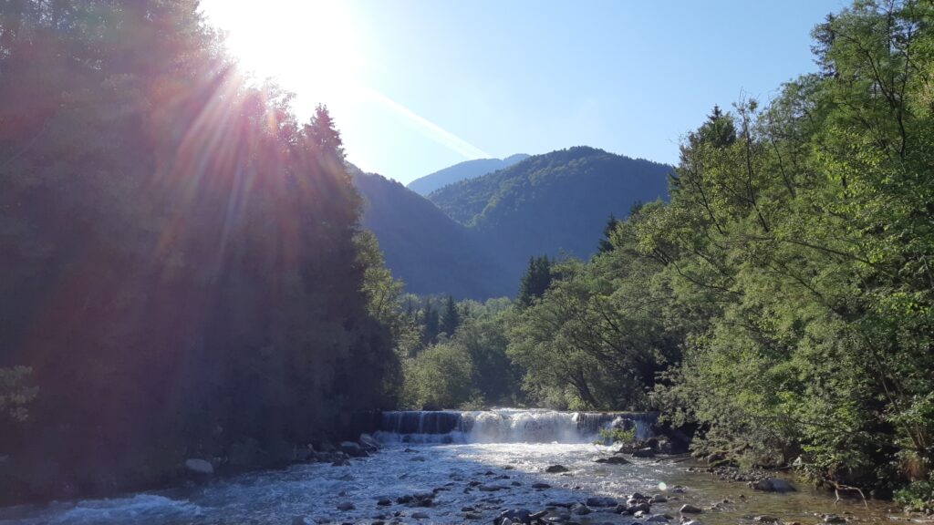 Wasserfall am Bach mit Sonne darüber